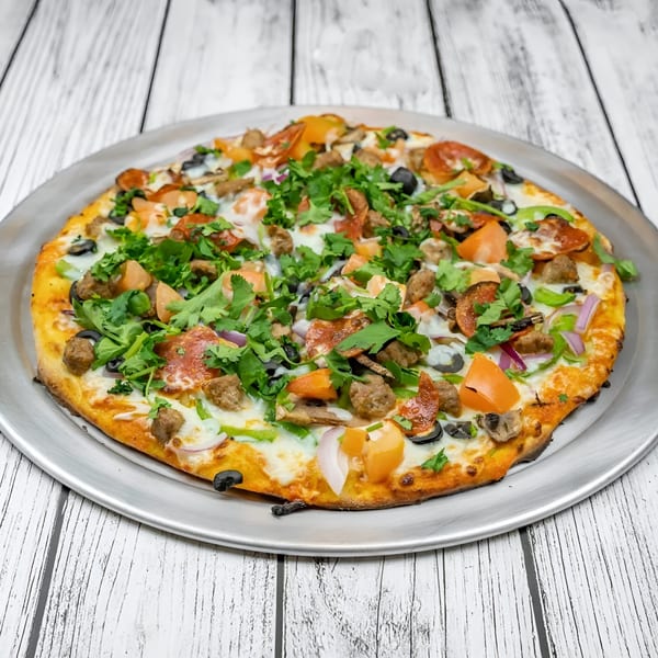 A Tadka Indian Restaurant pizza, topped with pepperoni, sausage, olives, peppers, and cilantro.